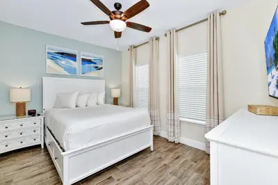 a white bedroom with a bed and a ceiling fan at Tropical Villa Near Disney With Margaritaville Resort & Island H20 Waterpark Access - 3005Cs in Orlando