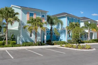a building with palm trees in a parking lot at Blue Sky Cottage Near Disney With Private Hot Tub & Margaritaville Resort & Island H20 Waterpark Access - 3008Sr in Orlando