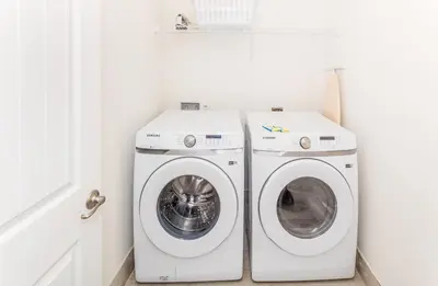a white laundry room with a washer and dryer at Comfy And Delightful Villa Near Disney With Margaritaville Resort & Island H20 Access - 8185Su in Orlando