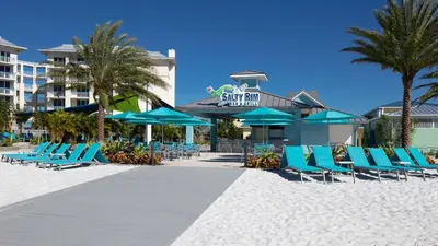 a group of blue chairs and umbrellas on a beach at Comfy And Delightful Villa Near Disney With Margaritaville Resort & Island H20 Access - 8185Su in Orlando