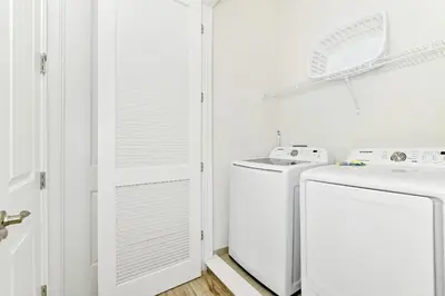 a white laundry room with a washer and dryer at Cozy Cottage With Private Pool Near Disney With Margaritaville Resort & Island H2O Access - 8028Kd in Orlando