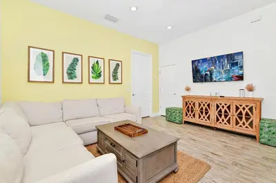 a living room with a couch and a table at Cozy Cottage With Private Pool Near Disney With Margaritaville Resort & Island H2O Access - 8028Kd in Orlando