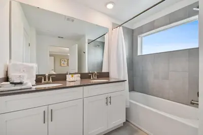 a bathroom with two sinks and a tub and a mirror at Storey Lake - Piscina privativa Cama King 4BD/3BA in Kissimmee