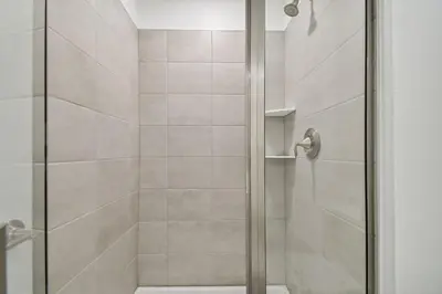 a bathroom shower with a glass shower door at Storey Lake - Piscina privativa Cama King 4BD/3BA in Kissimmee