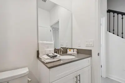 a white bathroom with a sink and a mirror at Storey Lake - Piscina privativa Cama King 4BD/3BA in Kissimmee