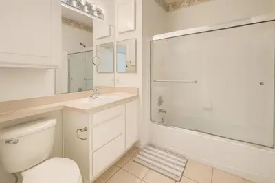 a bathroom with a toilet and a sink and a shower at Conforto e Espaço: Apt de 2Q e 2B em Legacy Dunes in Kissimmee