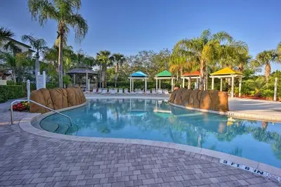 a pool at a resort with palm trees and gazebos at Conforto e Espaço: Apt de 2Q e 2B em Legacy Dunes in Kissimmee