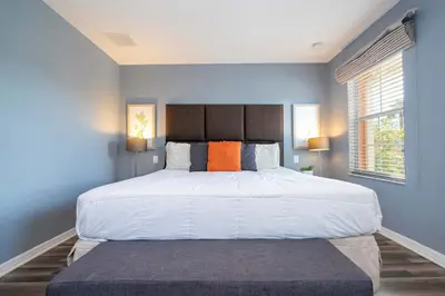 a bedroom with a large bed with an orange pillow at Cozy 2Bd Spa & Jacuzzi Close to Disney at Encantada 3029 in Kissimmee