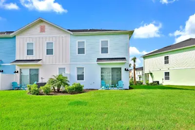 a large white house with a green lawn at Bright Blue Villa Near Disney With Margaritaville Resort & Island H20 Waterpark Access - 3085Cs in Orlando