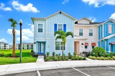 a white and blue house with a palm tree at Bright Blue Villa Near Disney With Margaritaville Resort & Island H20 Waterpark Access - 3085Cs in Orlando