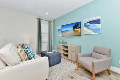 a living room with a couch and a chair at Blissful Villa Near Disney With Margaritaville Resort & Island H20 Waterpark Access - 3109Cs in Orlando