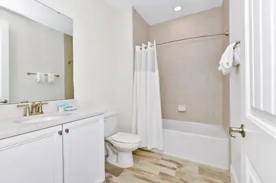 a white bathroom with a toilet and a sink at Blissful Villa Near Disney With Margaritaville Resort & Island H20 Waterpark Access - 3109Cs in Orlando