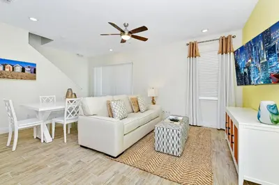 a living room with a white couch and a table at Tropical Villa Near Disney With Margaritaville Resort & Island H20 Waterpark Access - 3180Cs in Orlando