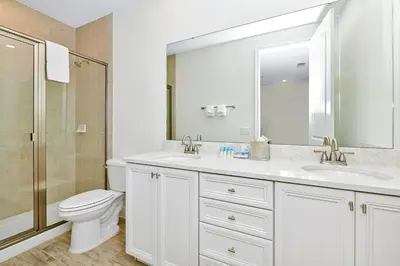 a white bathroom with a toilet and a sink at Tropical Villa Near Disney With Margaritaville Resort & Island H20 Waterpark Access - 3180Cs in Orlando