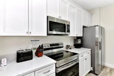 a kitchen with white cabinets and a stainless steel refrigerator at Pleasant Villa Near Disney With Margaritaville Resort & Island H20 Access - 2916Or in Orlando