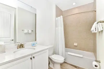 a white bathroom with a toilet and a sink at Spacious Villa Near Disney With Margaritaville Resort & Island H20 Waterpark Access - 2938Cl in Orlando