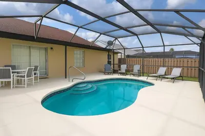 a patio with a swimming pool with a roof at Vista para o lago Casa c/piscina in Kissimmee