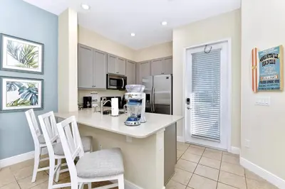 a kitchen with a counter with chairs and a counter top at Casa Blanca Cottage With Hot Tub Near Disney With Margaritaville Resort & Island H2O Access - 8032Su in Orlando