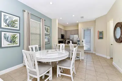 a dining room with a white table and chairs at Casa Blanca Cottage With Hot Tub Near Disney With Margaritaville Resort & Island H2O Access - 8032Su in Orlando