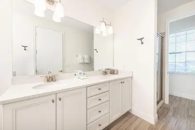 a white bathroom with a sink and a mirror at No Shoes Retreat! Cottage With Hot Tub Near Disney With Margaritaville Resort & Island H2O Access - 8085Dr in Orlando