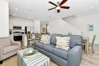 a living room with a blue couch and a ceiling fan at Sunny Villa Near Disney With Margaritaville Resort & Island H20 Access - 8170Cp in Orlando