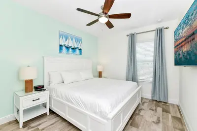 a bedroom with a white bed and a ceiling fan at Sunny Villa Near Disney With Margaritaville Resort & Island H20 Access - 8170Cp in Orlando