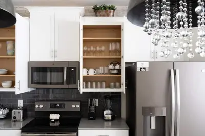 a kitchen with white cabinets and a black refrigerator at 5 BR Disney themed bedrooms SL 4825 in Kissimmee