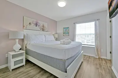 a bedroom with a white bed and a window at Encantada Resort: Pool, Gym, Clubhouse, Near Disney in Kissimmee