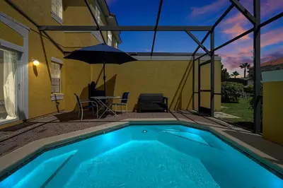 a swimming pool with a table and an umbrella at Encantada Resort: Pool, Gym, Clubhouse, Near Disney in Kissimmee