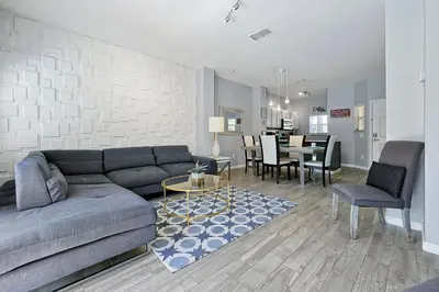 a living room with a couch and a dining room at Encantada Resort: Pool, Gym, Clubhouse, Near Disney in Kissimmee