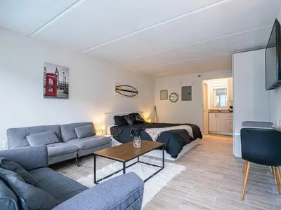 a living room with a couch and a bed at Spacious 1BR Stay Near Disney parks With pool view in Kissimmee