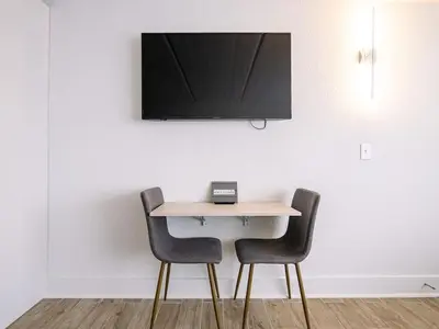 a table with two chairs and a television on a wall at Fun filled 1BR Close to Disney Parks With Lake view in Vineland