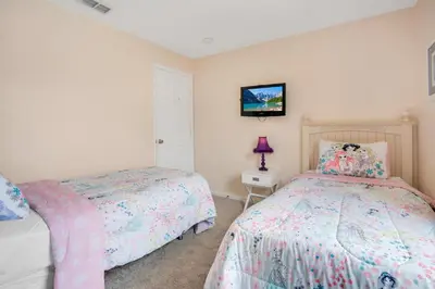 a bedroom with two beds and a tv on the wall at Relaxing Retreat in the Windsor Palms Resort in Kissimmee