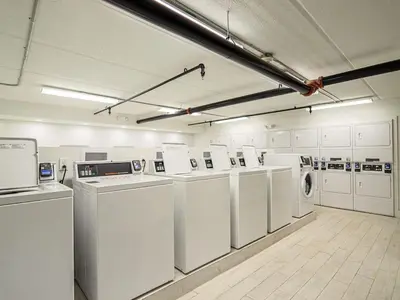 a large laundry room with white washers and dryers at Delightful 1BR Condo Next to Disney With Lake view in Vineland