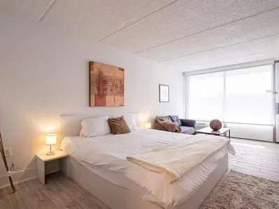 a white bedroom with a large bed and a window at Lovely 1BR Suite Minutes to Disney With Lake view in Vineland