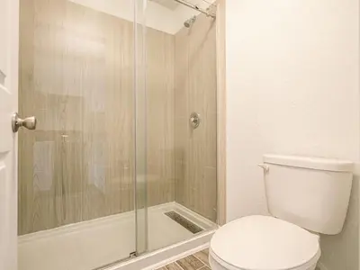 a bathroom with a toilet and a glass shower at Elegant 1BR Haven in Orlando & 5 minutes to Disney in Vineland