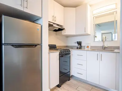 a kitchen with white cabinets and a stainless steel refrigerator at Welcoming 1BR Gateway Orlando 5 minutes to Disney in Vineland