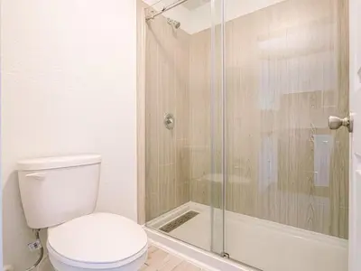 a bathroom with a toilet and a glass shower at Welcoming 1BR Gateway Orlando 5 minutes to Disney in Vineland