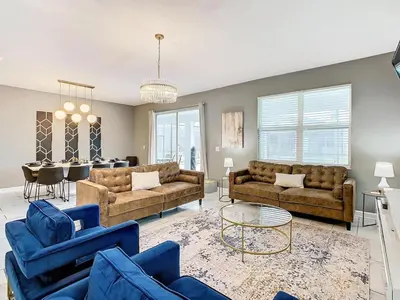 a living room with couches and a dining room at Once Upon a Villa in Kissimmee