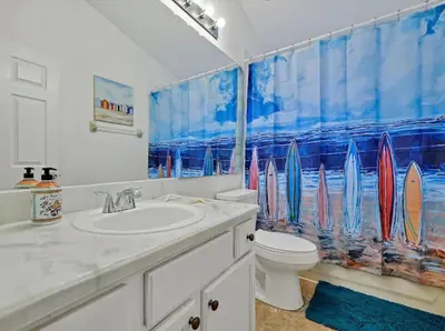 a bathroom with a sink and a toilet and a shower curtain at 6BD - Pool, BBQ & Movie Theater - 10 Mins to Disney in Kissimmee