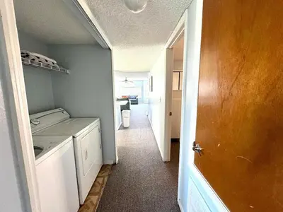 a hallway of a kitchen with a washer and dryer at 2492 Your home away from Home in Kissimmee