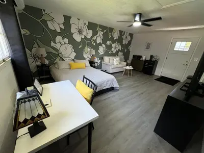 a living room with a bed and a table in a room at The Sanford Foodie Guest House in Sanford