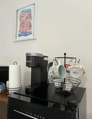 a counter with cups and a basket on top of a microwave at The Sanford Foodie Guest House in Sanford