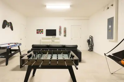 a living room with a ping pong table and a couch at 2612 LunaPi Villa 7Bd Private Pool and Family Room in Kissimmee