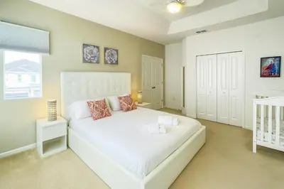 a bedroom with a white bed and a window at 2612 LunaPi Villa 7Bd Private Pool and Family Room in Kissimmee