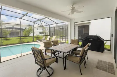 a dining room with a table and chairs and a pool at 2612 LunaPi Villa 7Bd Private Pool and Family Room in Kissimmee
