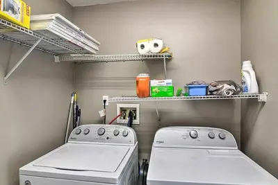 a laundry room with two white machines and shelves at 4 Bed Villa in Kissimmee, Orlando in Kissimmee
