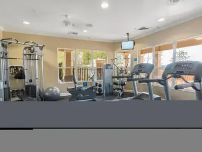a gym with several treadmills and exercise machines at Condo in Gated Windsor Hills in Orlando