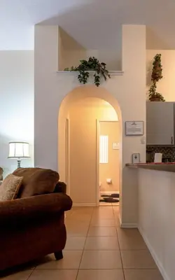 a living room with a couch and an archway at 4 Bed Villa - Eagle Pointe - Kissimmee in Kissimmee