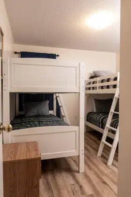 two white bunk beds in a room with wooden floors at 4 Bed Villa - Eagle Pointe - Kissimmee in Kissimmee